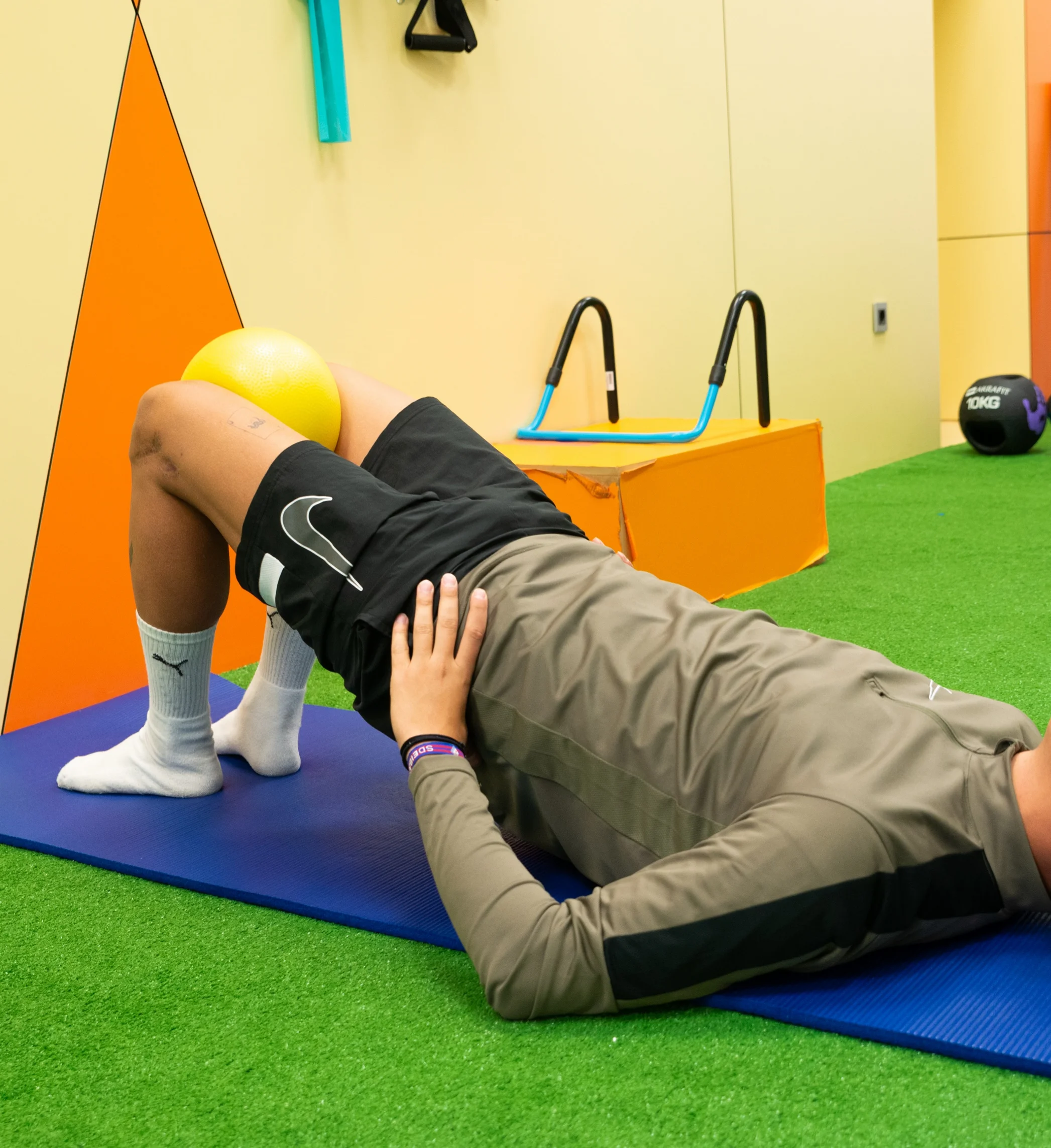 Persona acostada en el piso haciendo haciendo ejercicios de fisioterapia deportiva
